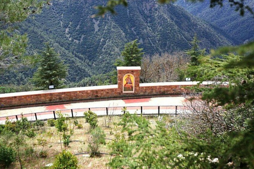 Paisaje montañoso con una estructura de ladrillo rojo que presenta un icono religioso. 2