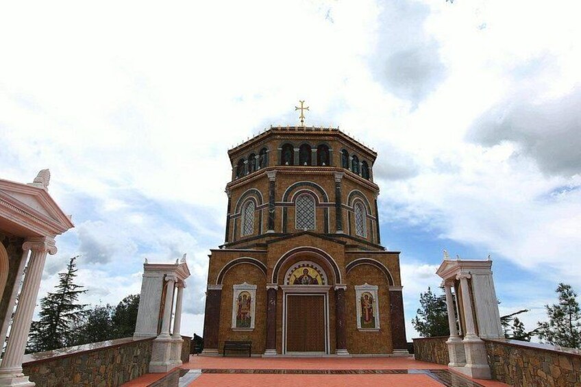 A church with a bell tower, arched windows, and a cross on top. 2
