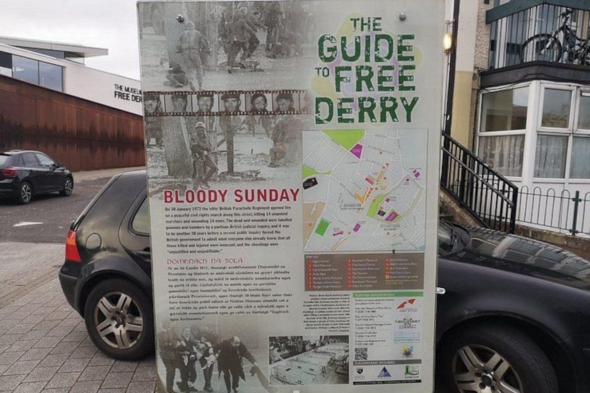 A historical information board titled 'The Guide to Free Derry' with a map and details about Bloody Sunday. 2
