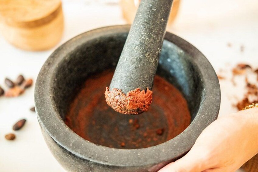 A mortar with a pestle grinding spices. 2