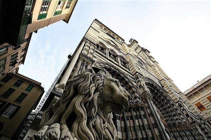 Un edificio alto con una escultura de león en su base. 3