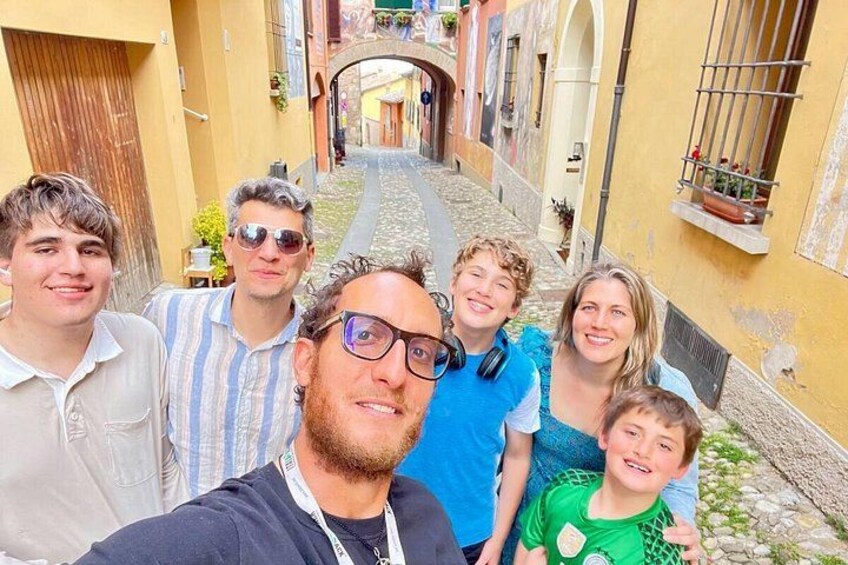 A group of people in a narrow street with buildings on either side. 4