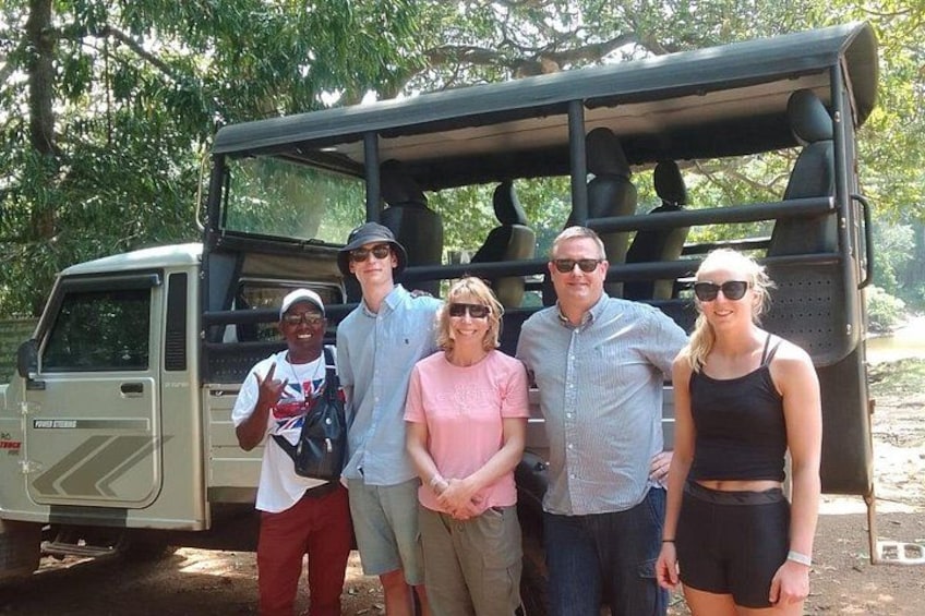 Un groupe de personnes se tient devant un véhicule de safari. 4