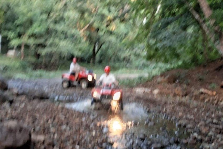 A vehicle driving through a muddy terrain with a person wearing a helmet. 4