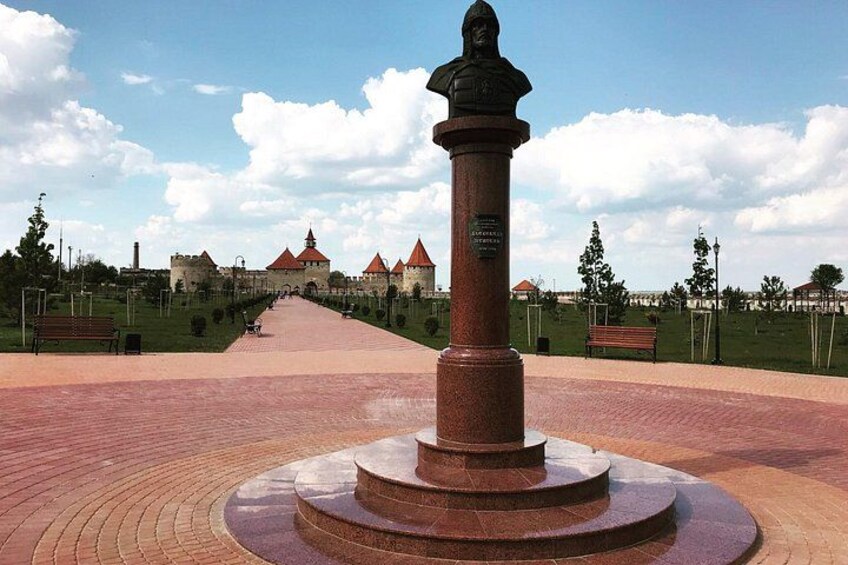Un monumento en un parque, con un castillo al fondo. 3