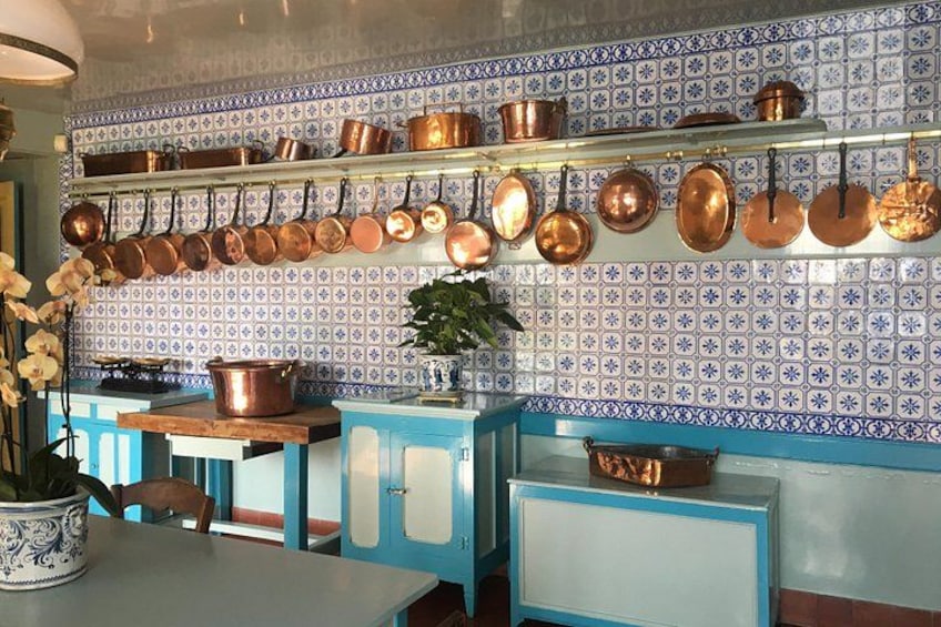 A kitchen with blue cabinets, a tiled backsplash, and copper cookware. 5