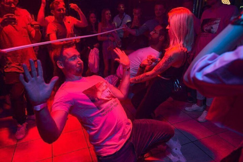 Un evento en interiores concurrido donde personas bailan e interactúan. 3