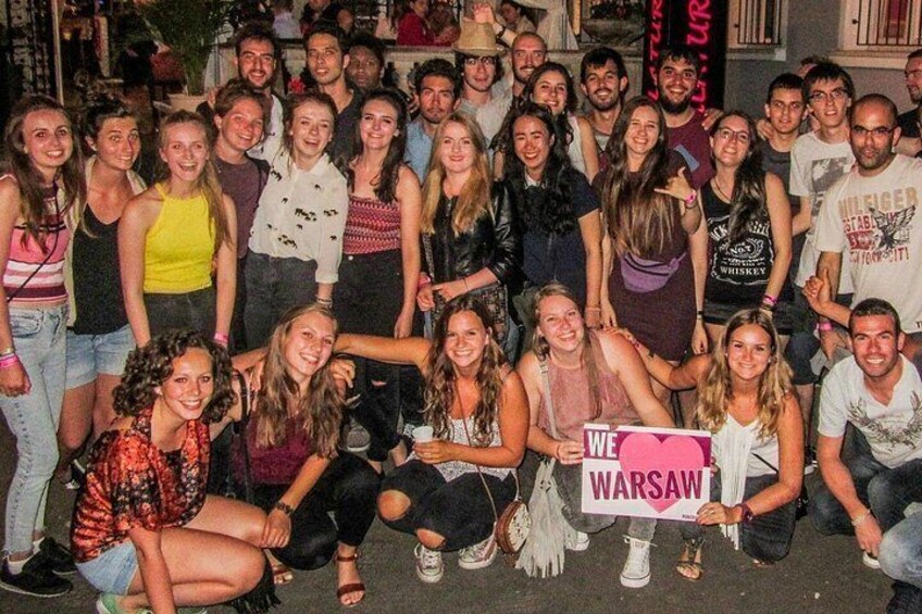 Un grupo de personas posando para una foto, sosteniendo un cartel que dice 'WE WARSAW'. 4