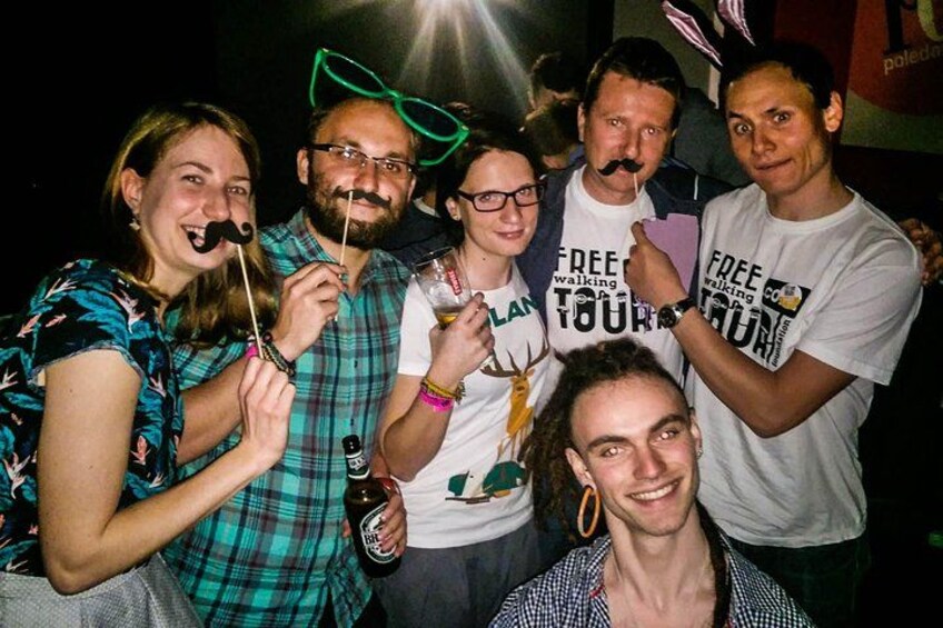 A group of people at a social event, some wearing casual clothing and others in themed t-shirts. 2