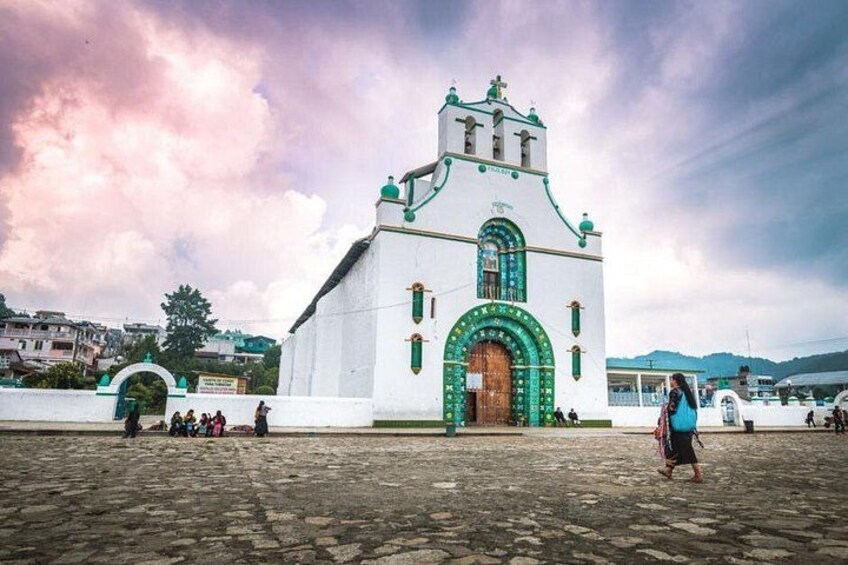 A white church with a green door and a bell tower. 2