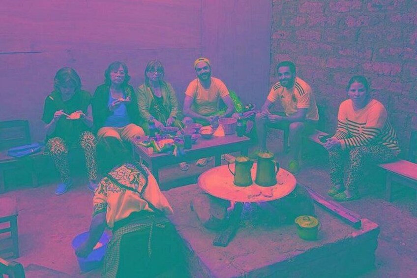 A group of people sitting around a table with various items, including a pitcher and a bowl. 3