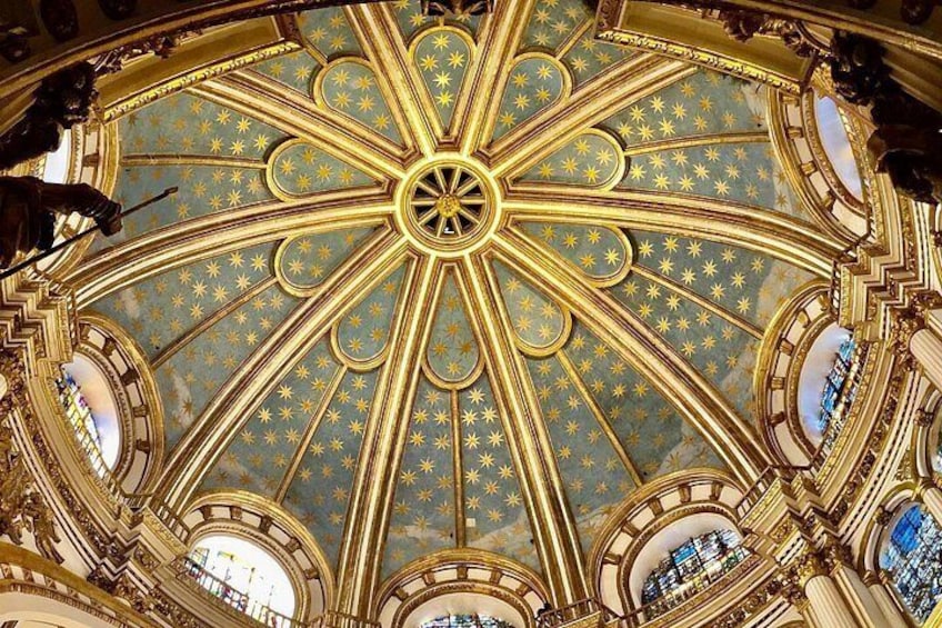 A grand, ornate ceiling with a starry pattern and a central circular design. 5