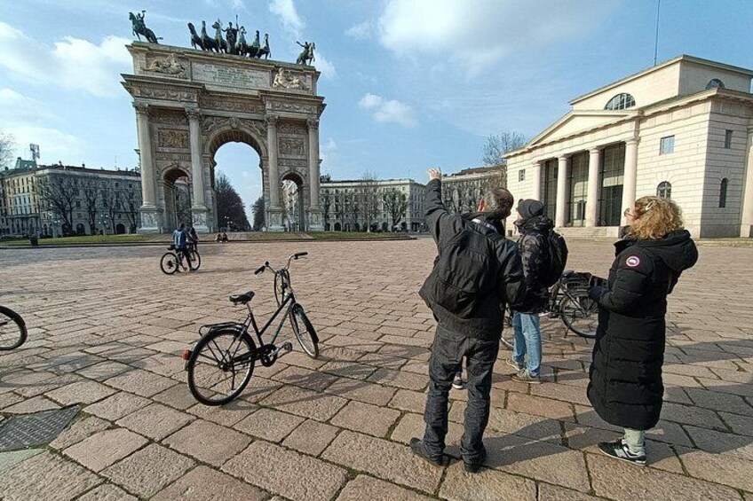 En historisk buegang, en cykel og en bygning med søjler. 5