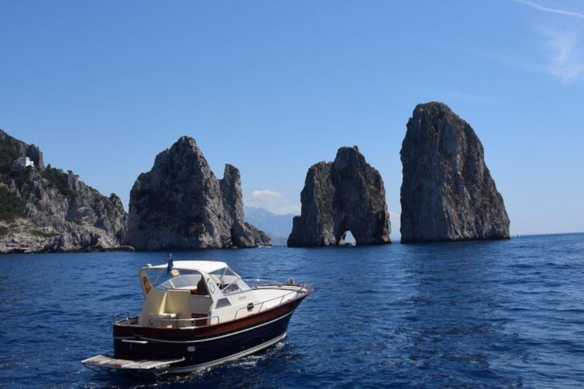 Un bateau sur une eau calme, avec des falaises rocheuses en arrière-plan. 1