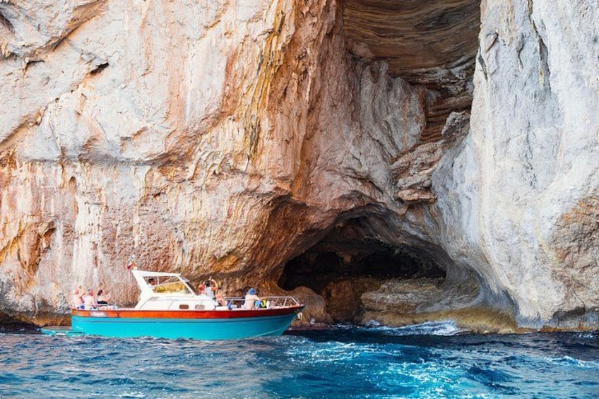 Un bateau près d’une côte rocheuse, à proximité de l’entrée d’une grotte. 4