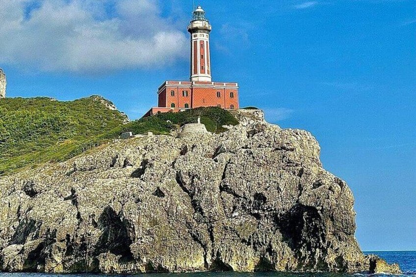 Un phare perché sur une falaise rocheuse, sous un ciel bleu dégagé. 2