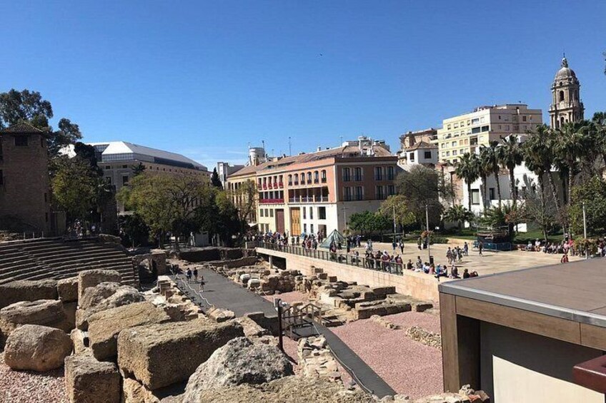 Ancient ruins, a modern building, and a plaza with people. 4