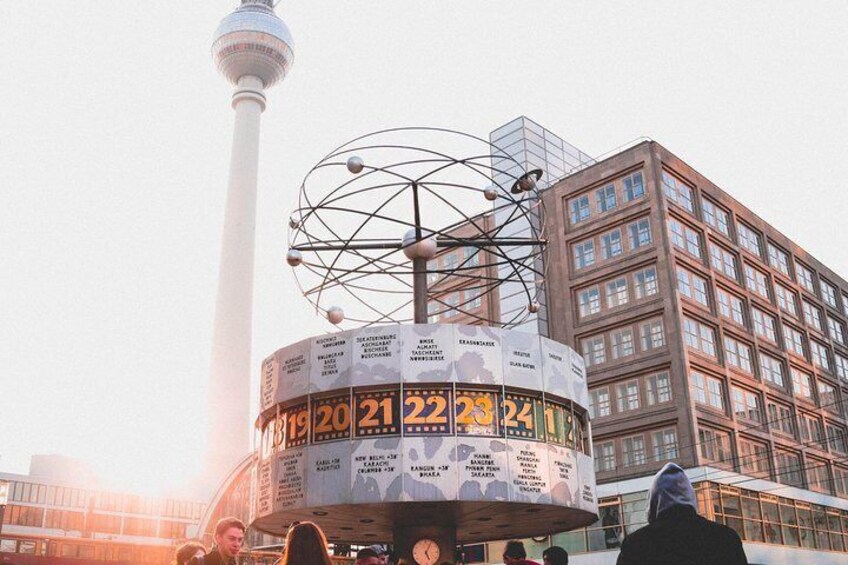 Una gran estructura circular con los números 20, 21, 22, 23, 24 y 25 en sus laterales, rodeada de edificios y una torre al fondo. 3