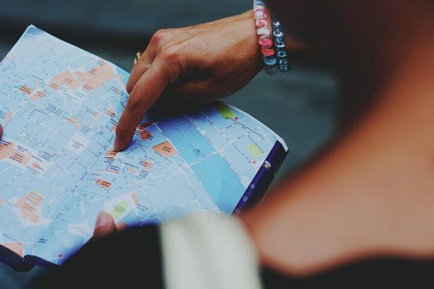 Una persona sosteniendo un mapa con varios lugares marcados. 4