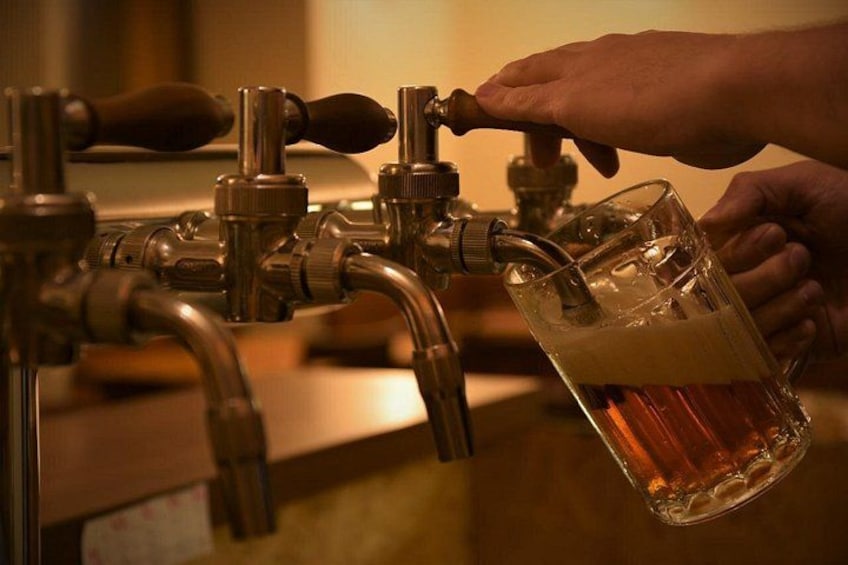Una mano sirviendo cerveza de un grifo en un vaso. 2