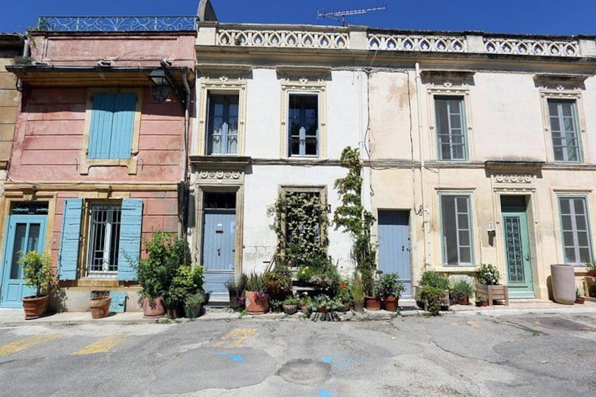Una fila di edifici colorati con persiane blu e piante in vaso. 1