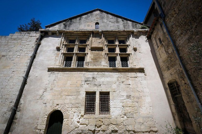 Un edificio storico in pietra con finestre ad arco e un portale centrale. 2