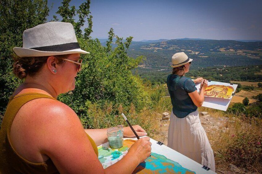 Two people painting outdoors with a landscape in the background. 2