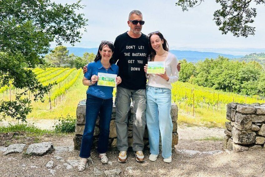 A group of people standing in a vineyard with rows of grapevines in the background. 5