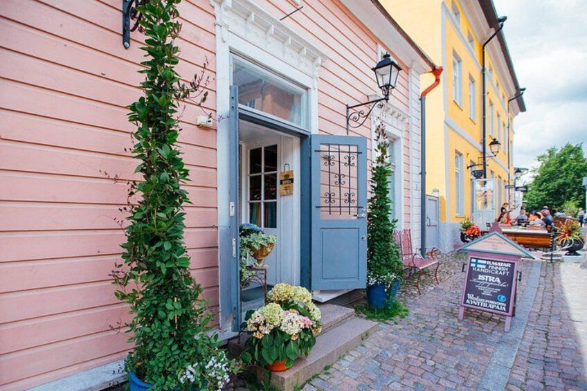 A pink building with a blue door, a yellow building, and a signboard. 3