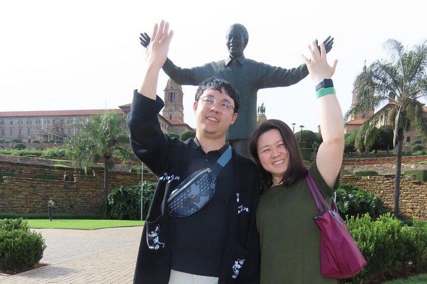 A person taking a selfie with a statue in the background. 2