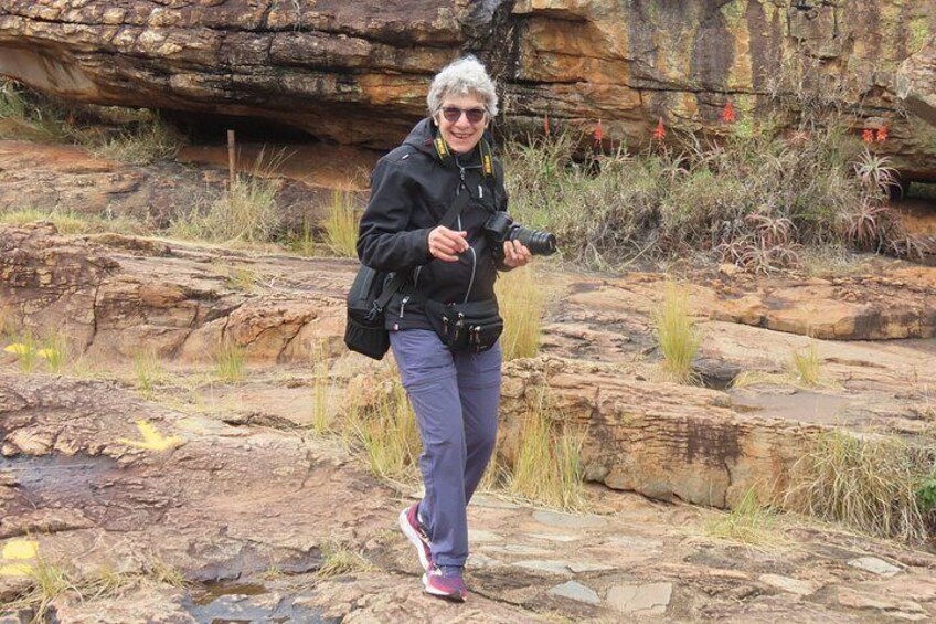 A person hiking on rocky terrain with a camera. 2