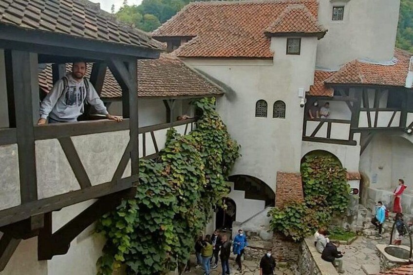 Un bâtiment de style médiéval doté d’un balcon en bois, de murs recouverts de lierre et d’une cour intérieure en pierre. 2