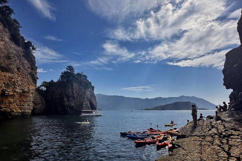 A rocky shoreline with boats and people. 2
