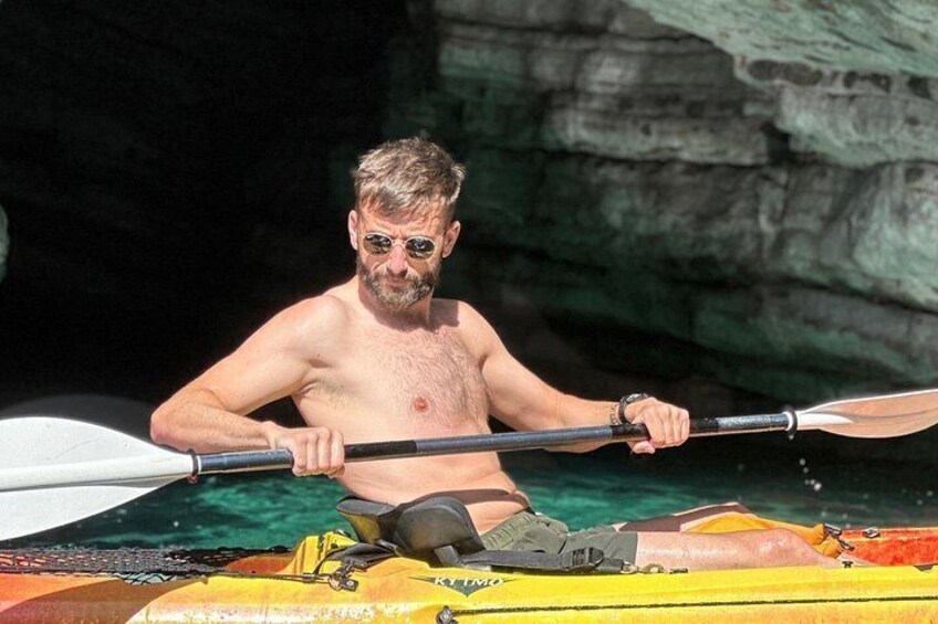 Budva Kayak & SUP Rental – man smiling in an orange kayak inside Pigeon Cave, Montenegro 2