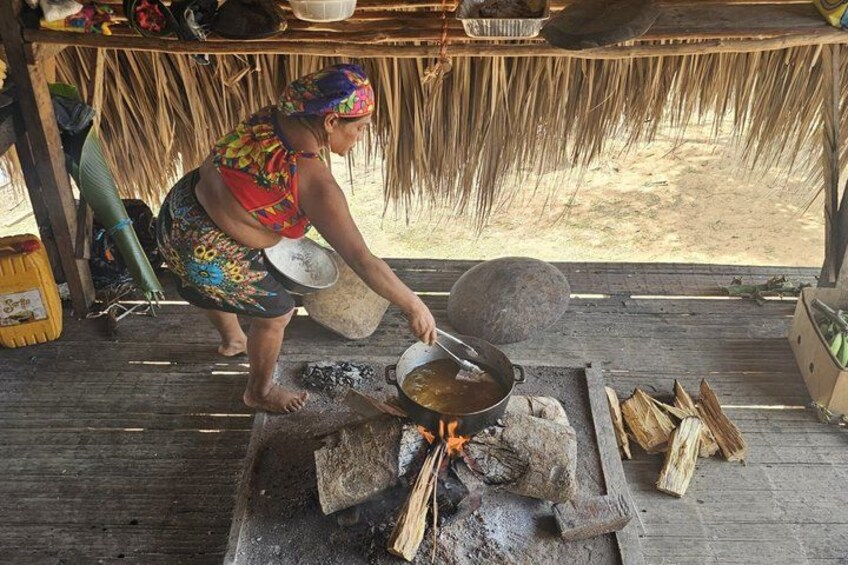 Una persona cocinando al aire libre usando un fogón tradicional con leña. 5
