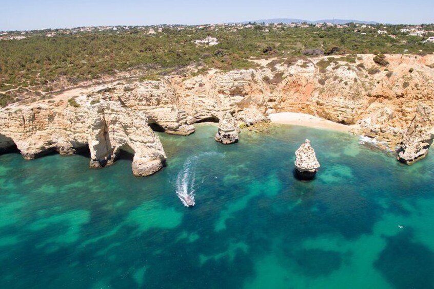 A coastal landscape with rocky formations and clear turquoise waters. 5