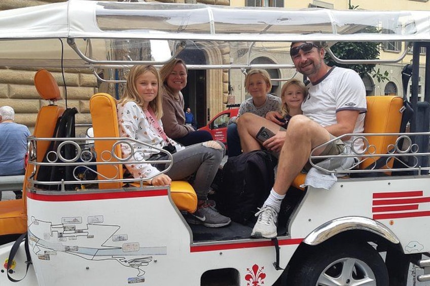 A group of people on a white and orange bus with a map on the side. 1
