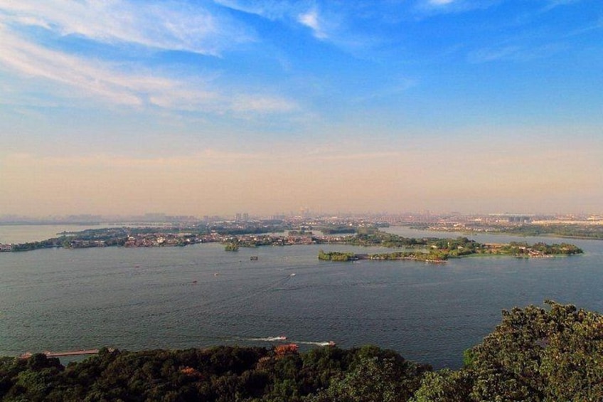 Un paisaje costero con una gran extensión de agua, varias islas pequeñas y el horizonte de una ciudad a lo lejos. 3