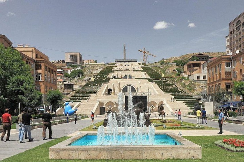 A fountain, steps leading to a building, and people walking. 1