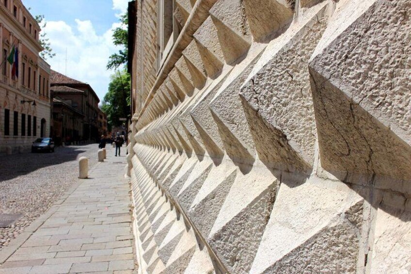 Une rue pavée bordée d’un mur de pierres présentant un motif géométrique. 2