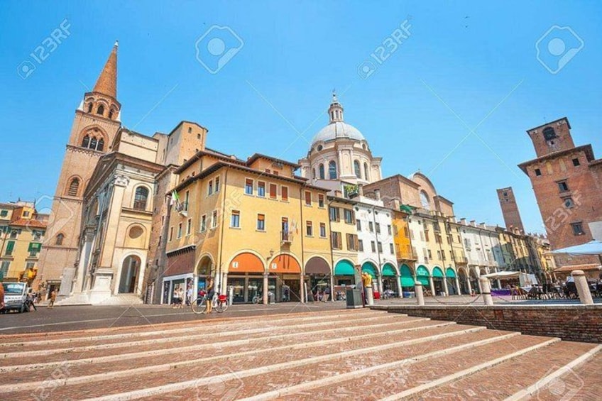 A historic building with a dome and a bell tower, a pedestrian area with steps, and a clear blue sky. 3