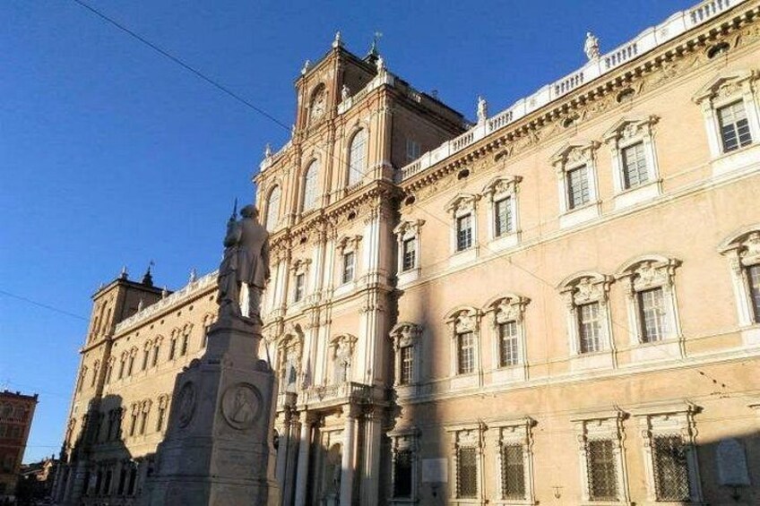 A historic building with ornate architecture, a prominent clock tower, and a statue. 2