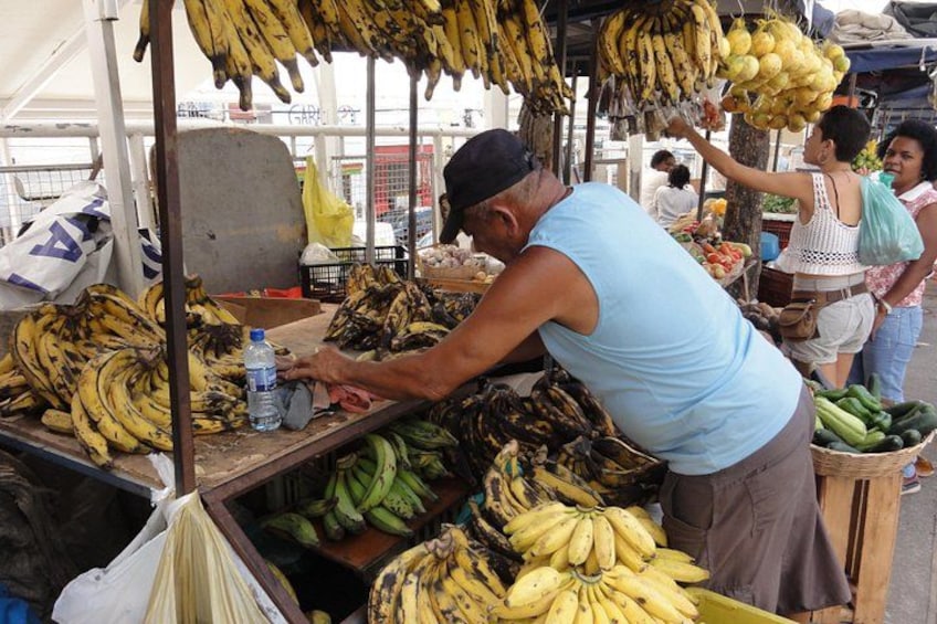 Un vendedor ofreciendo plátanos en un puesto de mercado. 1