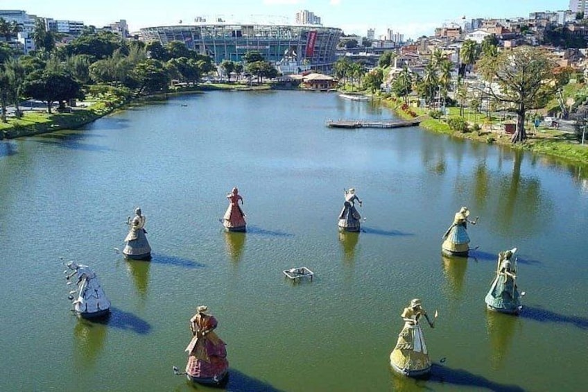 Un lago con estatuas de mujeres vestidas con ropas de época. 4