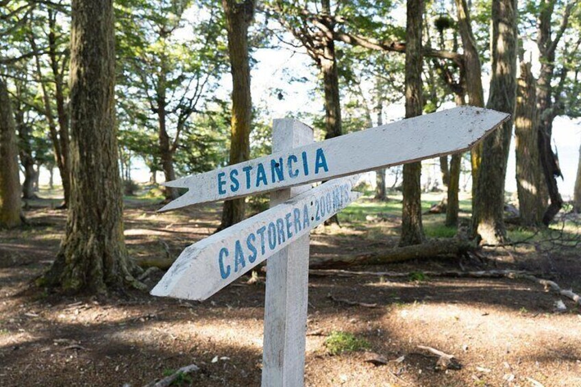 A wooden signpost with directional arrows pointing to 'Estancia' and 'Castoreira'. 3