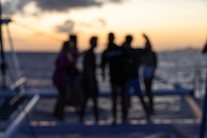 Un grupo de personas en un barco durante el atardecer. 2