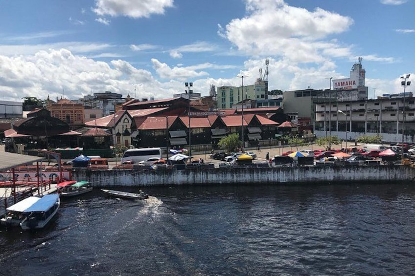 En badebro med fortøjede både, en Yamaha bygning og en bysilhouet med forskellige bygninger. 3