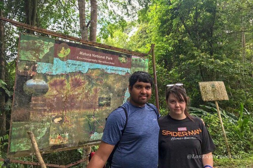 Two people standing in front of a signboard at Mature National Park. 5
