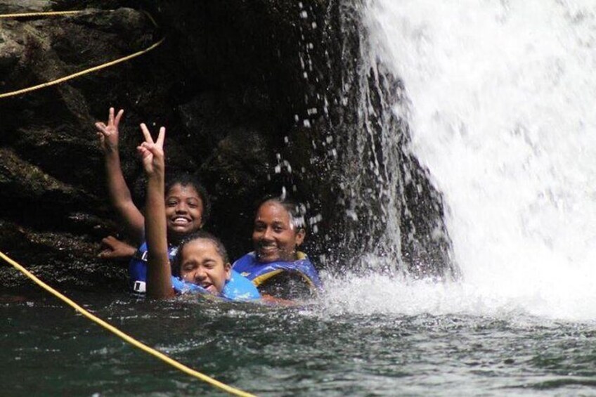 Three people in water near a waterfall. 4