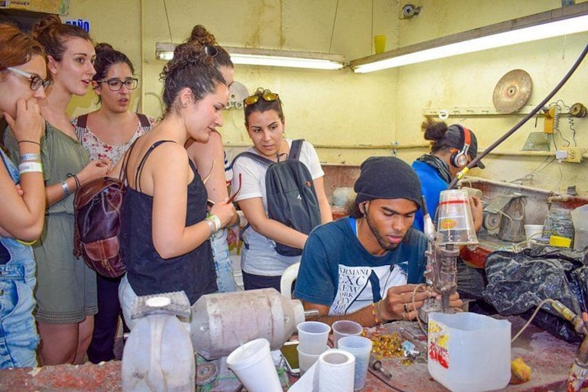 Un grupo de personas participa en una actividad artesanal, con varias herramientas y materiales sobre una mesa. 2